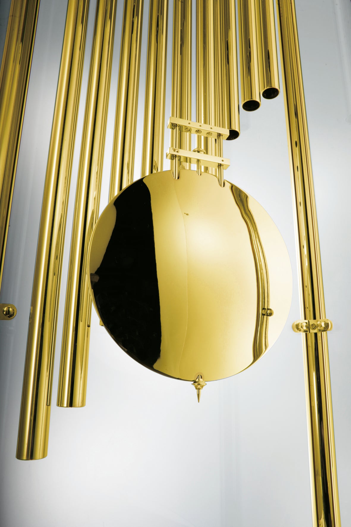Close-up of a reflective golden sphere surrounded by metallic tubes.