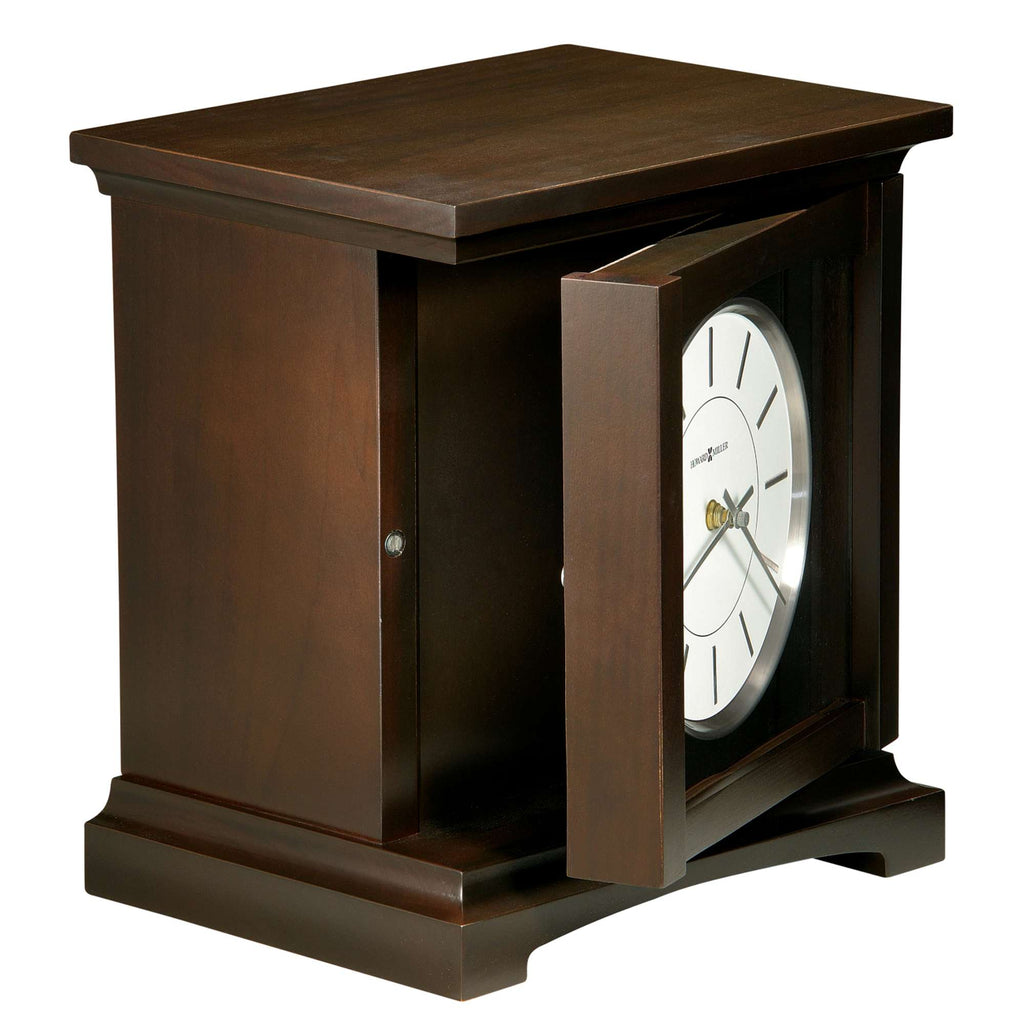 A wooden mantel clock with an open door, displaying a white clock face.
