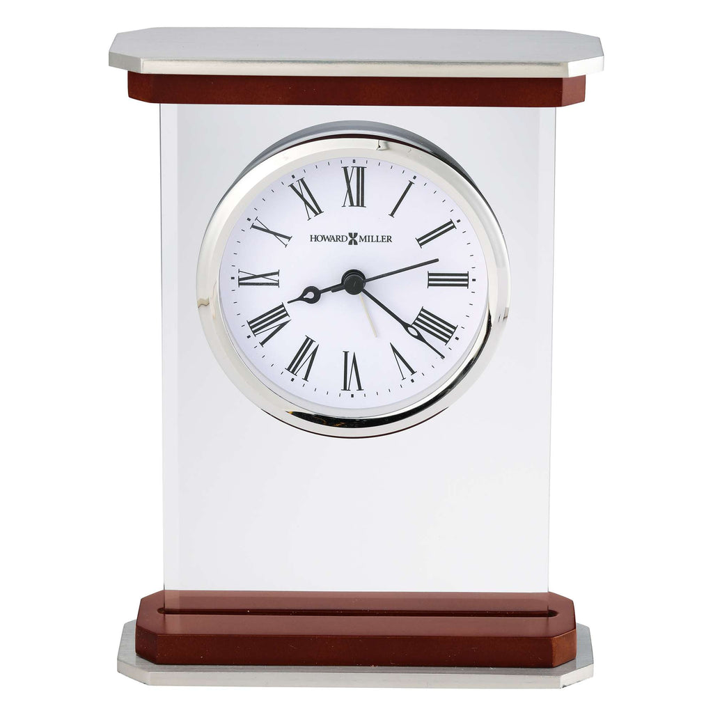 A modern desk clock with a transparent case and a round white face featuring Roman numerals and black hands.