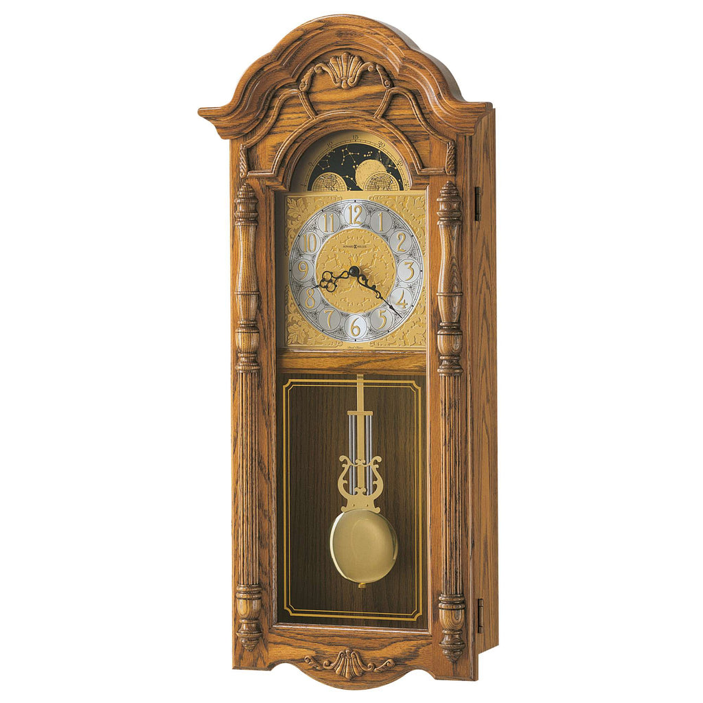 Antique wooden wall clock with ornate design and pendulum