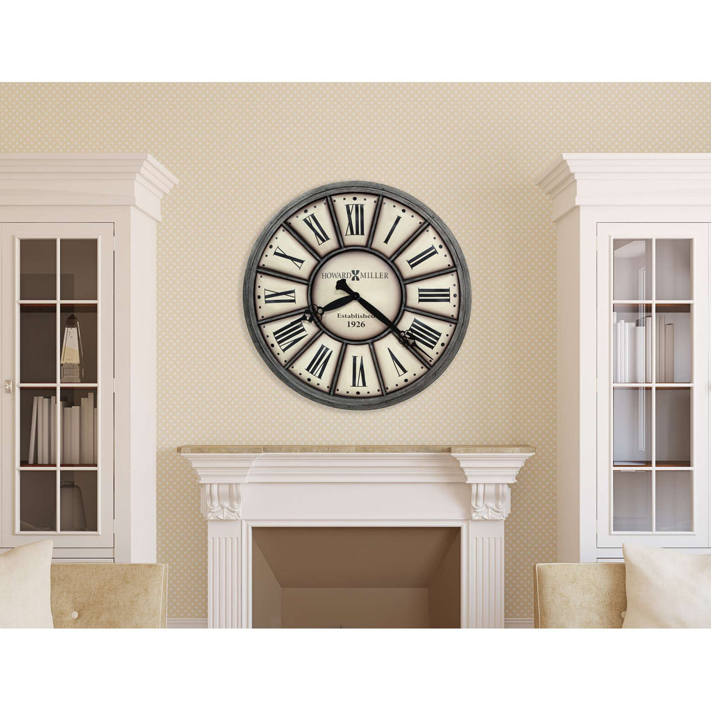 A round wall clock with Roman numerals hangs above a fireplace in a stylish living room.
