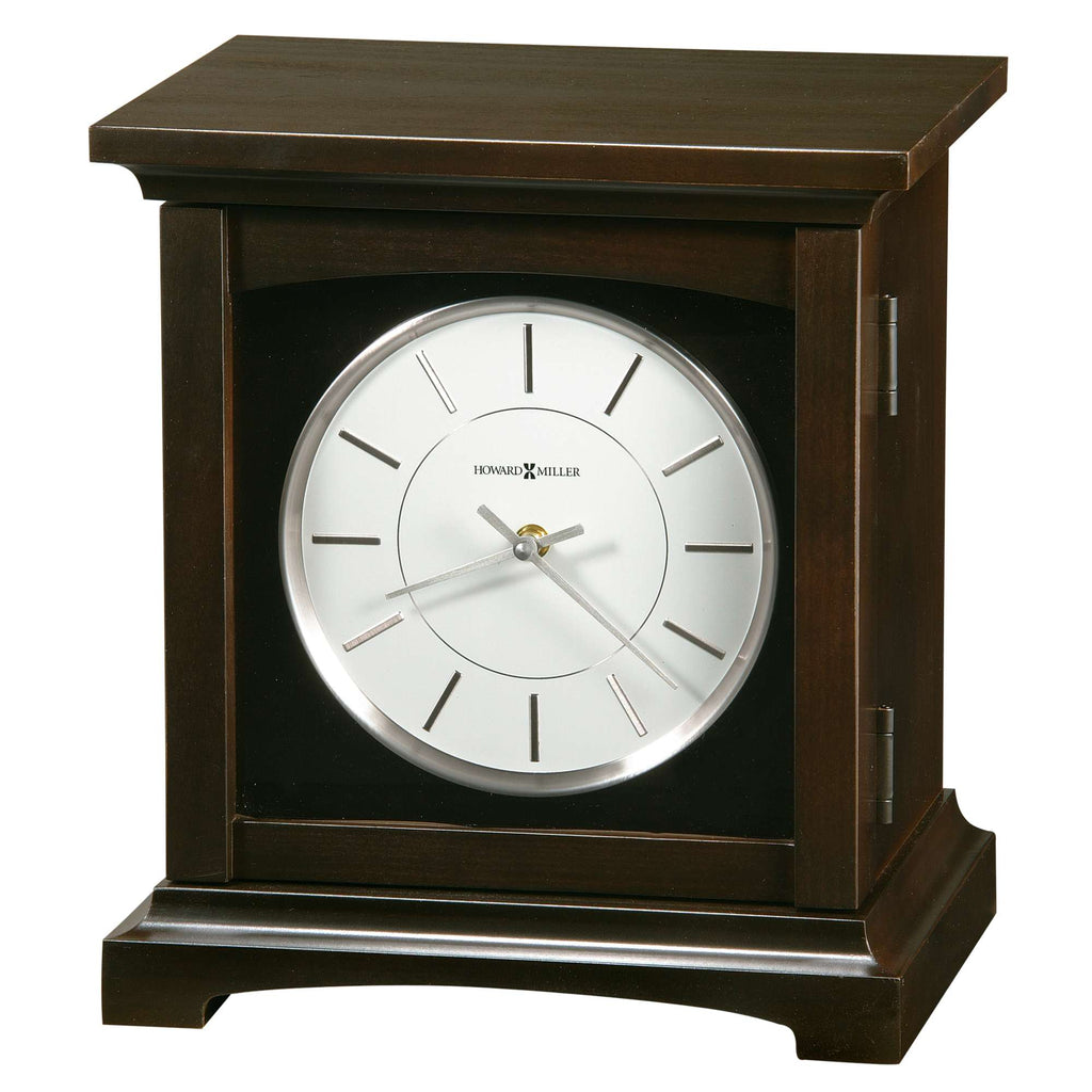 A wooden mantel clock with a round white face and silver accents.
