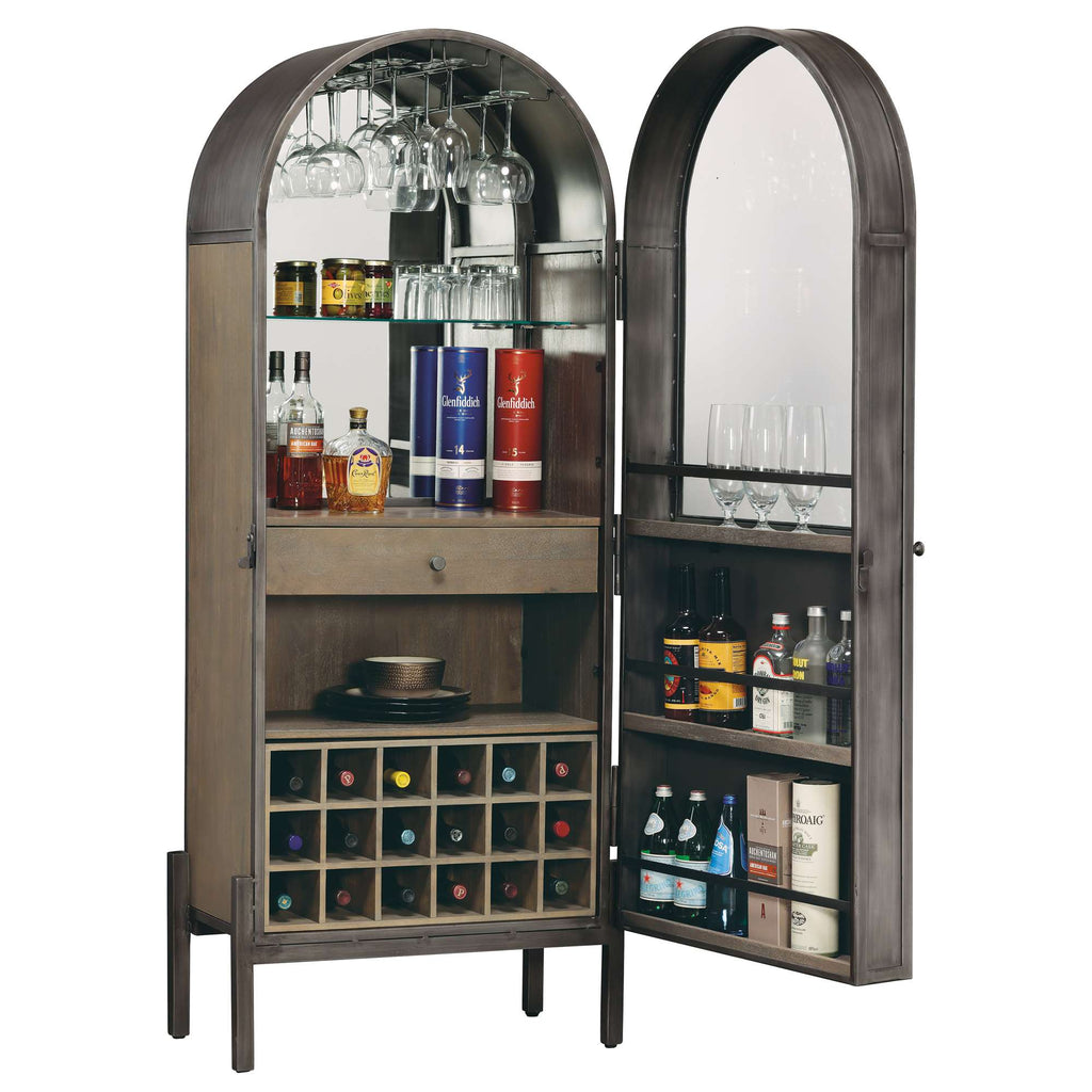 A stylish bar cabinet with arched doors, featuring shelves for glasses and a variety of liquor bottles.